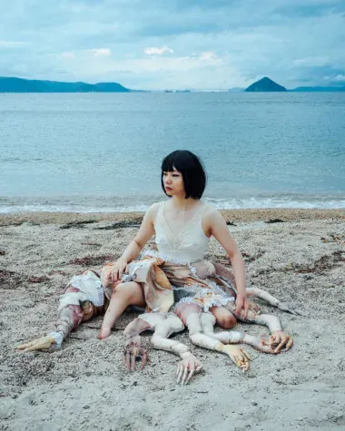 femme assise sur plage avec prothèses formant des tentacules 