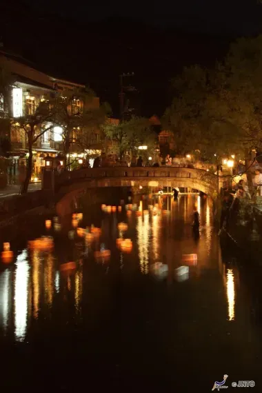 Las luces de Kinosaki Onsen se reflejan en las aguas del canal por la noche