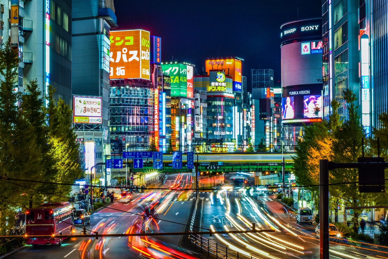 Neon lights of Shinjuku with car lights from a busy road
