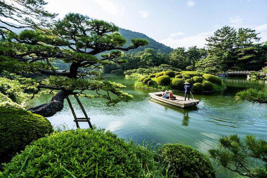 Visitors in a boat visiting a Japanese garden