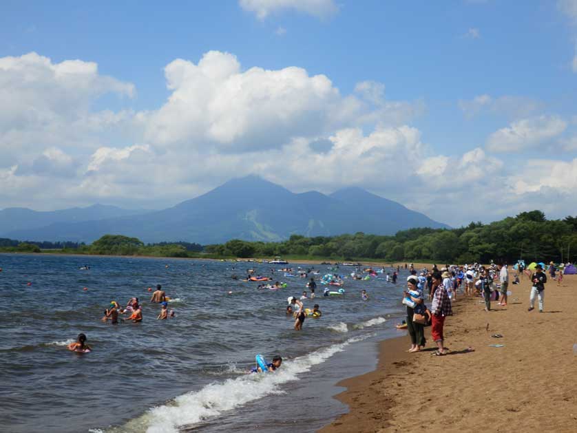 Swimming beach at Lake Inawashiro with Mount Bandai in the background.