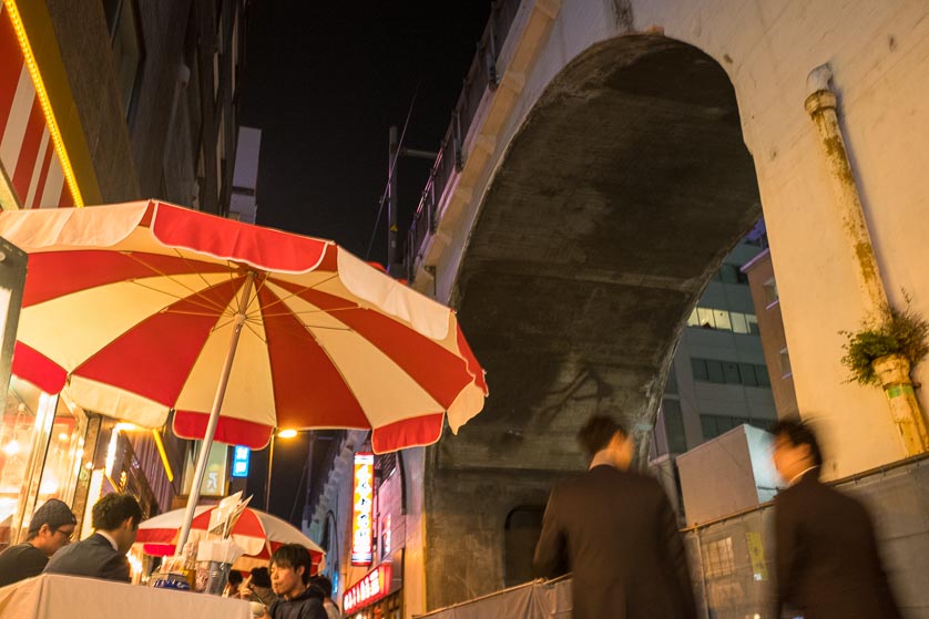 Outdoor cafe in Akihabara, Tokyo, under Chuo-Sobu Line arches.