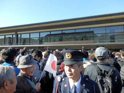 Policeman in the middle of the crowds waiting for the Emperor.