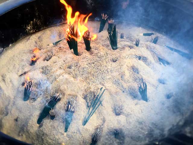 A guardian spirit adorns an incense holder.