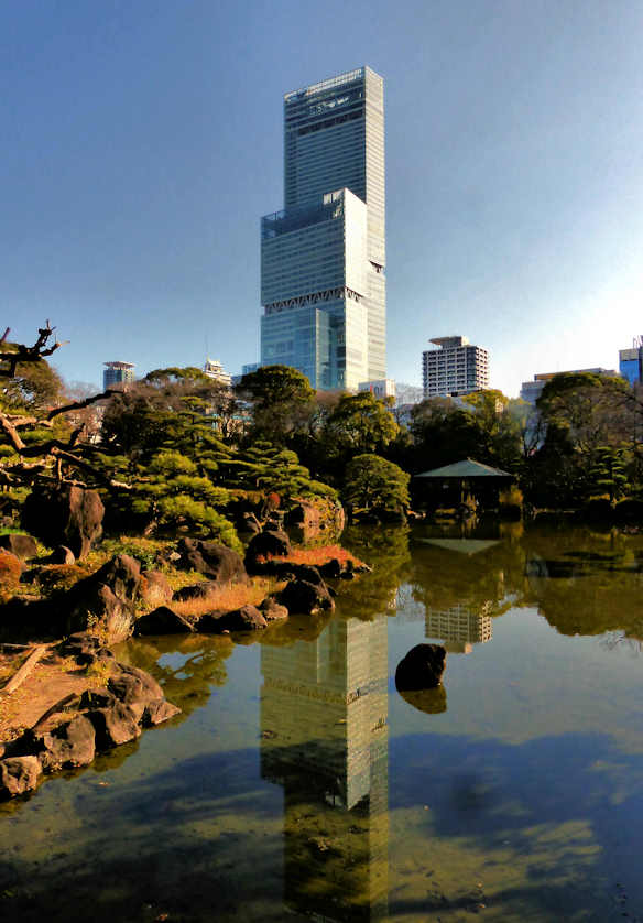 Abeno Harukas, the tallest building in Japan is reflected in the pond at Keitakuen Garden in Osaka.