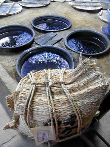 Indigo dye vats and a bundle of rami in the Yamaura family workshop, Kurume, Japan.