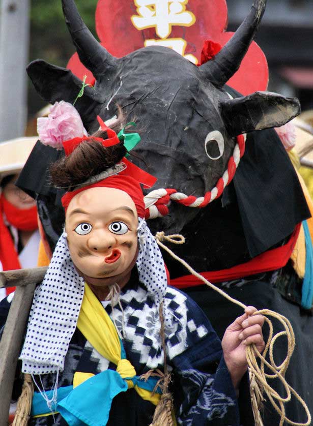 A figure in Hyottoko mask.