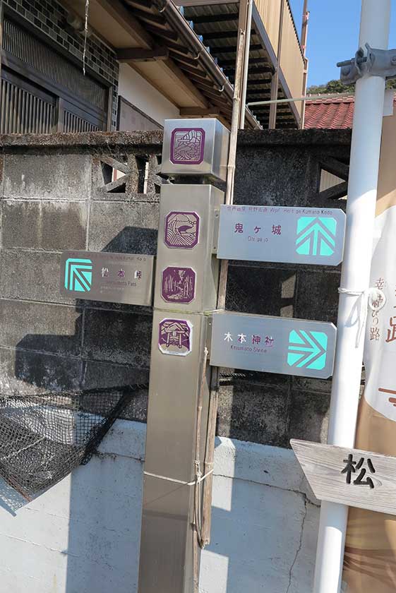 Sign pointing left to Matsumoto Toge Pass, straight ahead to Onigajo, and right to Kinomoto Shrine.