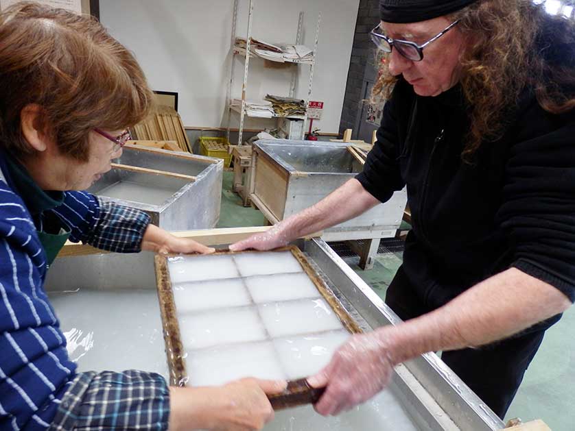 A visitor scoops paper pulp for postcard making, Saitama Craft Center, Ogawa.