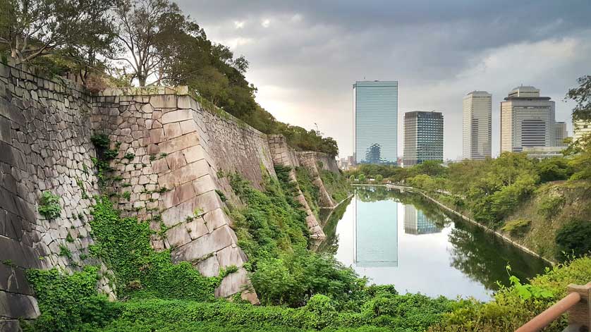 The walls of the castle with high rise buildings in the background.