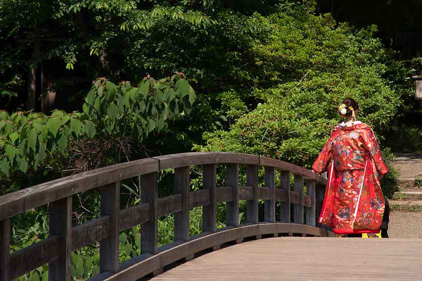 Kimono-clad woman on bridge, Sankeien Garden.