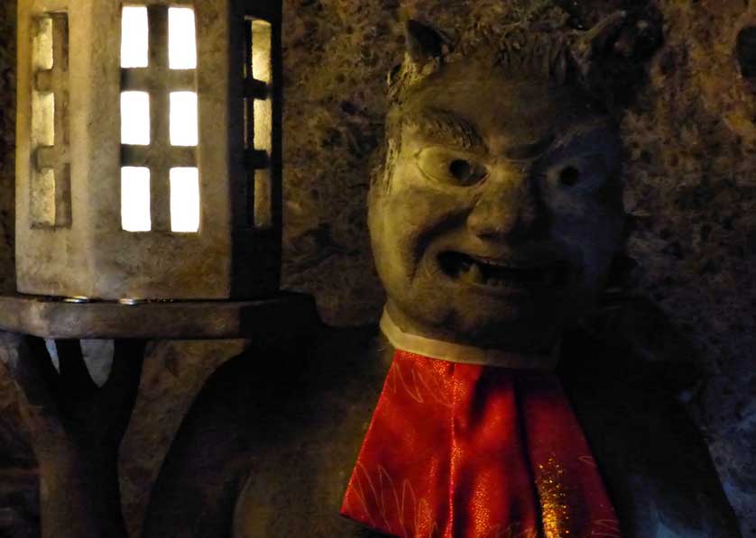 A demon holds a lantern illuminating the cave at Goishizan Temple, Shodoshima.