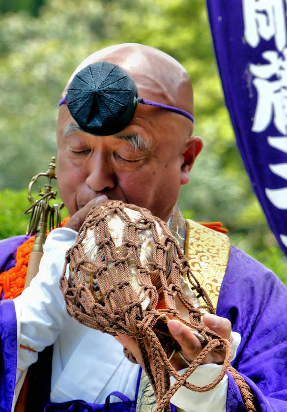 A yamabushi playing a horagai, a conch shell trumpet, as part of a Goma ritual.