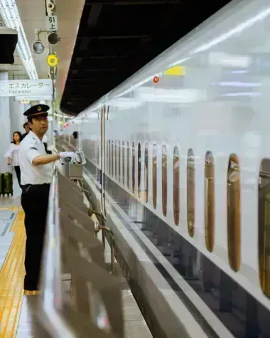 Personnel de train devant un Shinkansen 