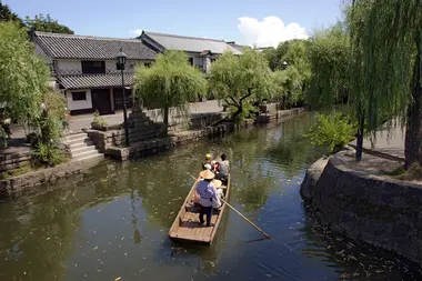 Promenade en bateau sur le canal dans le quartier historique de Kurashiki Bikan, Okayama