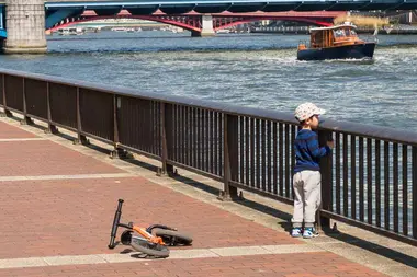 Boy looking at a boat on the Sumida River