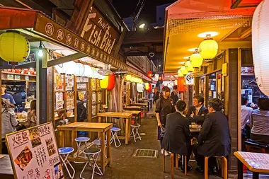 A busy street lined with izakaya