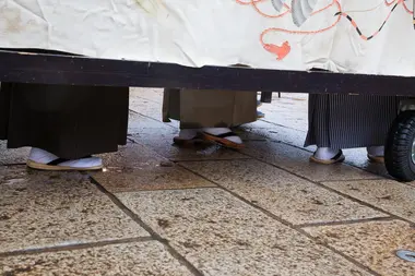 les jeunes chanteurs et musiciens cachés sous un char lors du festival Hikiyama matsuri de Johana