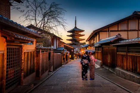 Two women in purple and pink standing on street in Gion, traditional district of Kyoto