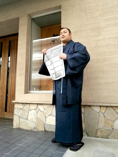 sumo Un somo arborant le banzuke, la liste officiel de tous les lutteurs de sumo