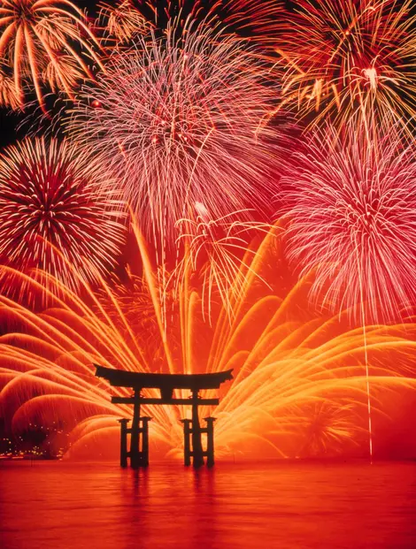 Fireworks behind the famous Miyajima torii gate. Fireworks before the famous Miyajima torii.