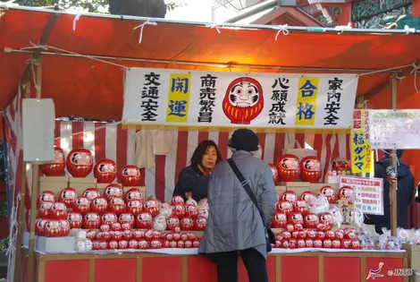 Stand de poupée Durama. Selon la légende, lorsque l'on dessine les yeux de la poupée, il faut  faire un vœux. 