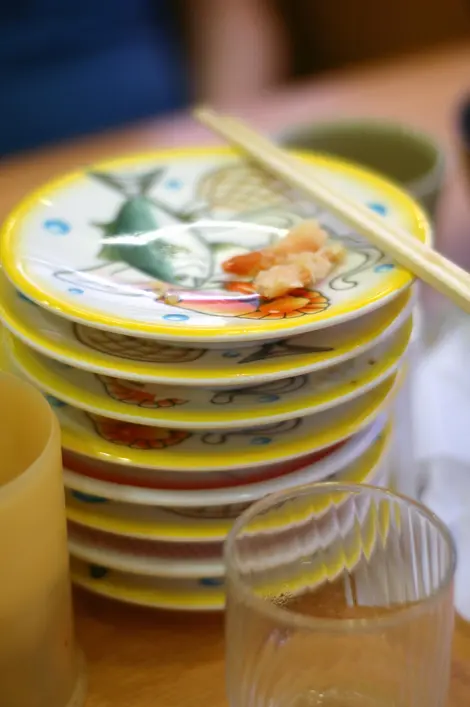 Les assiettes empilées après la fin d'un repas dans un kaitenzushi.