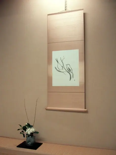This takemonois composed of a flower arrangement and calligraphy suggesting spring This takemonois composed of a flower arrangement and calligraphy suggesting spring
