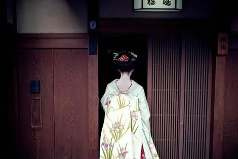 Geisha à l'entrée d'une maison de thé dans le quartier de Gion, à Kyoto Geisha à l'entrée d'une maison de thé dans le quartier de Gion, à Kyoto