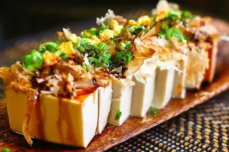 Hiya yakko : le tofu froid au gingembre, negi (poireaux japonais), bonite séchée et sauce soja Hiya yakko : le tofu froid au gingembre, negi (poireaux japonais), bonite séchée et sauce soja