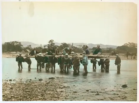 Des porteurs permettent aux voyageurs de passer la rivière sans danger. Des porteurs permettent aux voyageurs de passer la rivière sans danger.