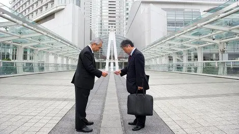 Dos japoneses se dan sus tarjetas de presentación.