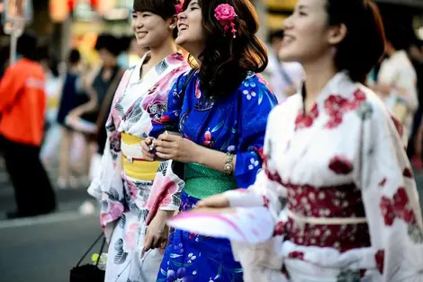 Jóvenes japonesas en yukata durante un matsuri Jóvenes japonesas en yukata durante un matsuri