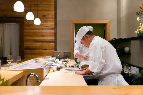 Un chef sushi préparant un poisson Un chef sushi préparant un poisson