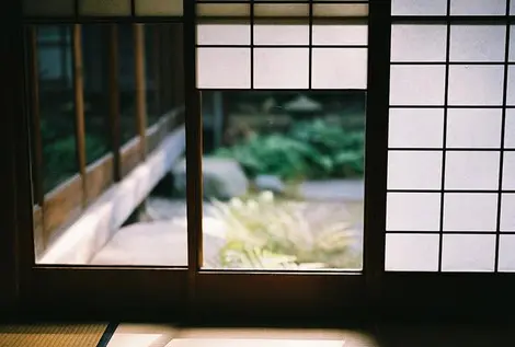 Séparant l'extérieur et l'intérieur de la maison, ces shoji laissent filtrer la lumière du jour Séparant l'extérieur et l'intérieur de la maison, ces shoji laissent filtrer la lumière du jour