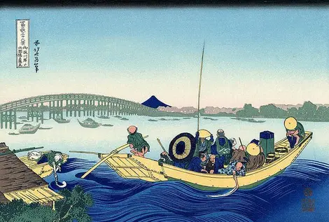 Coucher de soleil à travers le pont de Ryōgoku depuis la rive de la Sumida à Onmayagashi Coucher de soleil à travers le pont de Ryōgoku depuis la rive de la Sumida à Onmayagashi