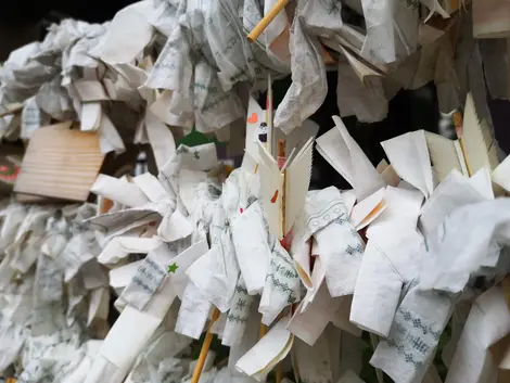 Certaines personnes accrochent le papier de l'omikuji avec la flèche