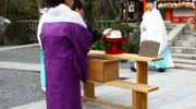 Una mujer que acaba de clavar sus agujas en el pedazo de tofu durante el Hari Kuyo.