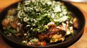 Un okonomiyaki tout juste servi.