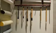 Hanging calligraphy brushes and paper on wall