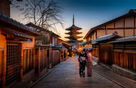 Two women in purple and pink standing on street in Gion, traditional district of Kyoto