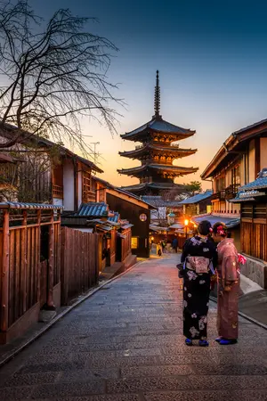 Two women in purple and pink standing on street in Gion, traditional district of Kyoto