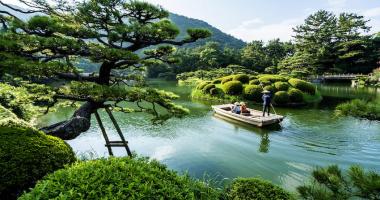Besucher in einem Boot, das einen japanischen Garten besucht
