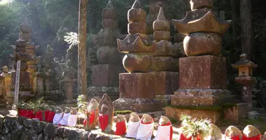 Buddhastatuen, die ein zinnoberrotes Lätzchen um den Hals tragen.
