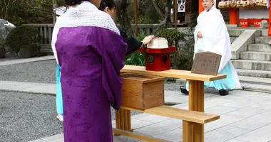 Una mujer que acaba de clavar sus agujas en el pedazo de tofu durante el Hari Kuyo.