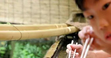 Un enfant essayant de saisir des nagashi-sômen à Kibune.