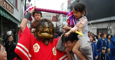 Les démons tapotent les passants (et surtout les enfants!) de leurs bâtons pour leur porter bonheur