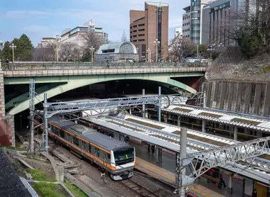 Yotsuya-mitsume Bridge (part of Shinjuku-dori Avenue) over Yotsuya Station, with Kojimachi Exit on far side of road