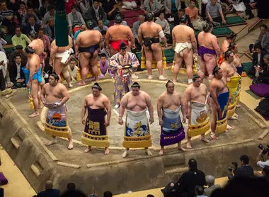 Rikishi surrounding the dohyo with the Gyoshi in the center Rikishi surrounding the dohyo with the Gyoshi in the center