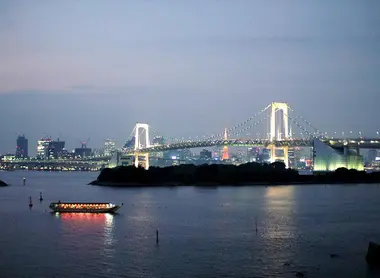 Une péniche yakatabune dérive tranquillement dans la baie de Tokyo, devant le pont Rainbow Bridge.